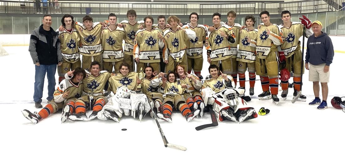 Canadian Hockey Club team and coaching staff posing on the ice with a championship trophy